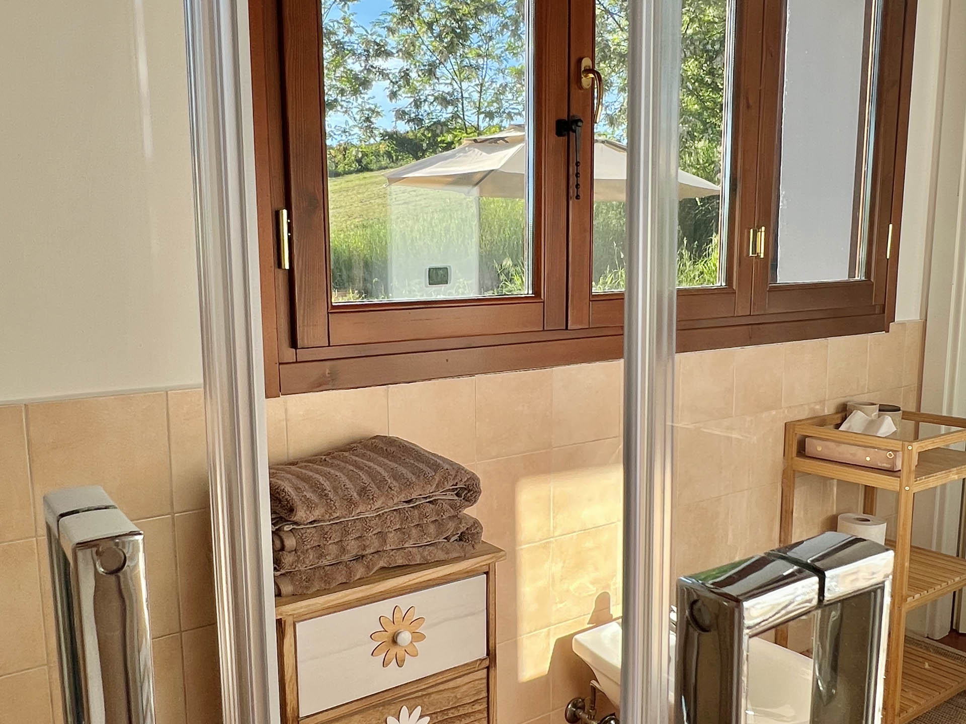 Bathroom with walk-in shower, towels and garden view in Dozza